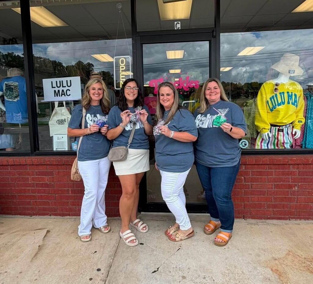 Four teachers outside a store, holding treats
