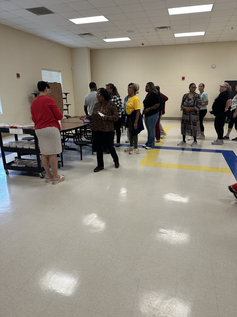 Mrs. Kidd passing out cinnamon rolls to the staff members during 2026 Learning Launch