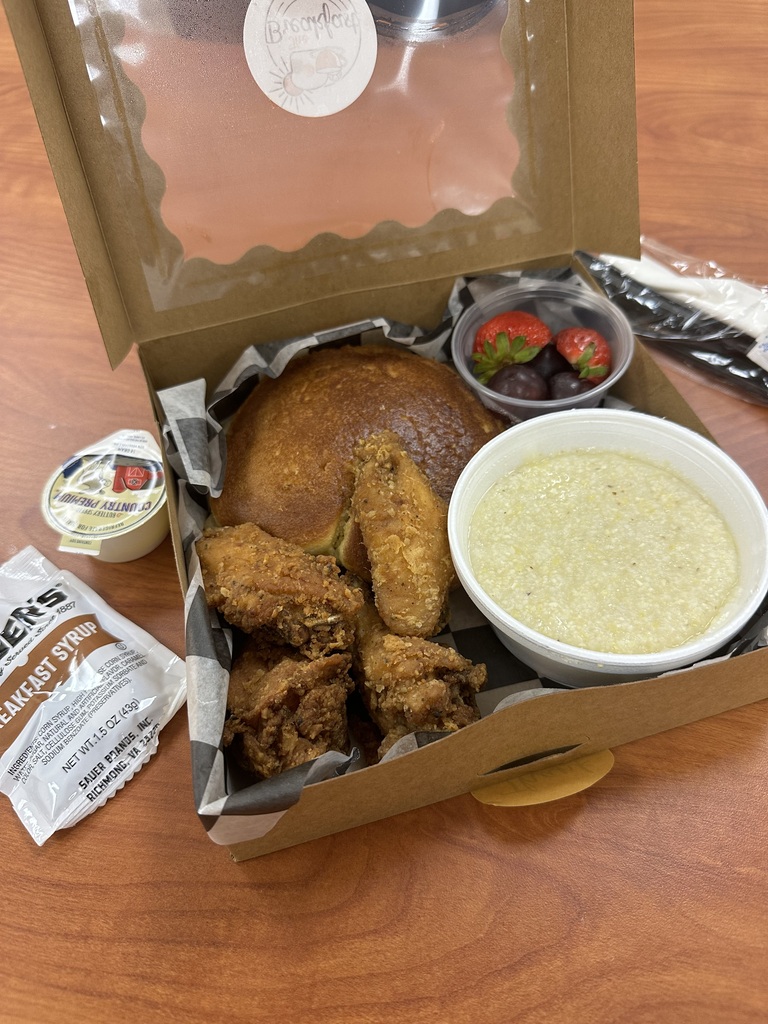 Brunch Box picture with grits, fruit, chicken, pancakes from Breakfast Spot