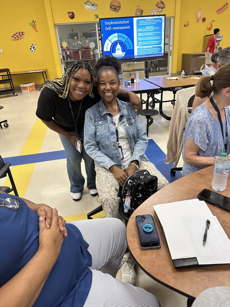 Two Paraprofessionals smiling in front of the ViewSonic board during our Learning Launch