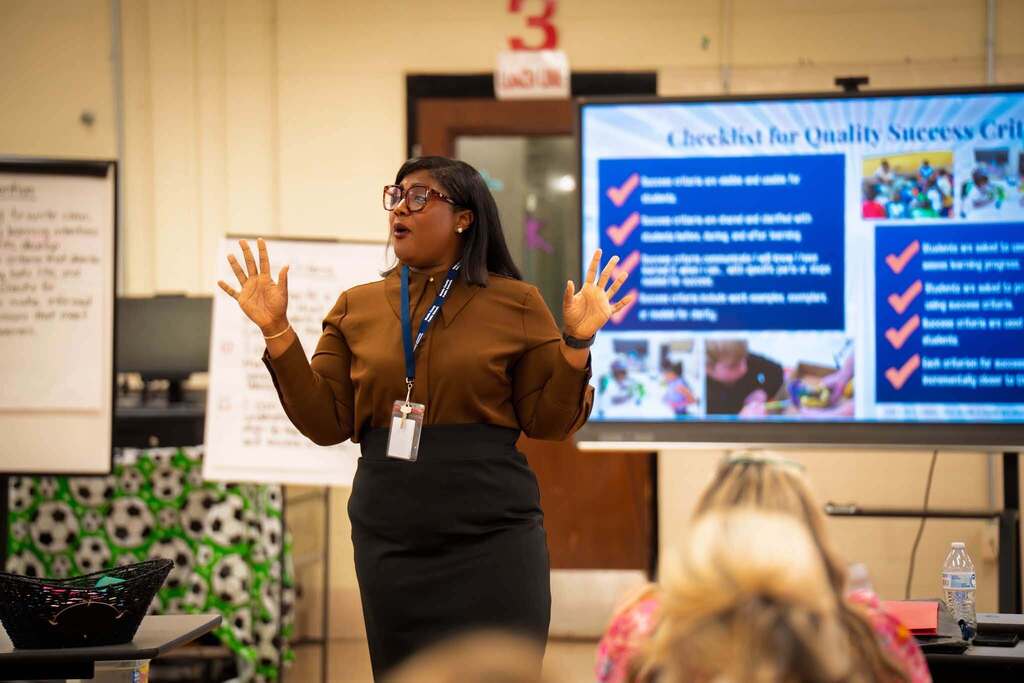 A woman speaking in a room full of teachers
