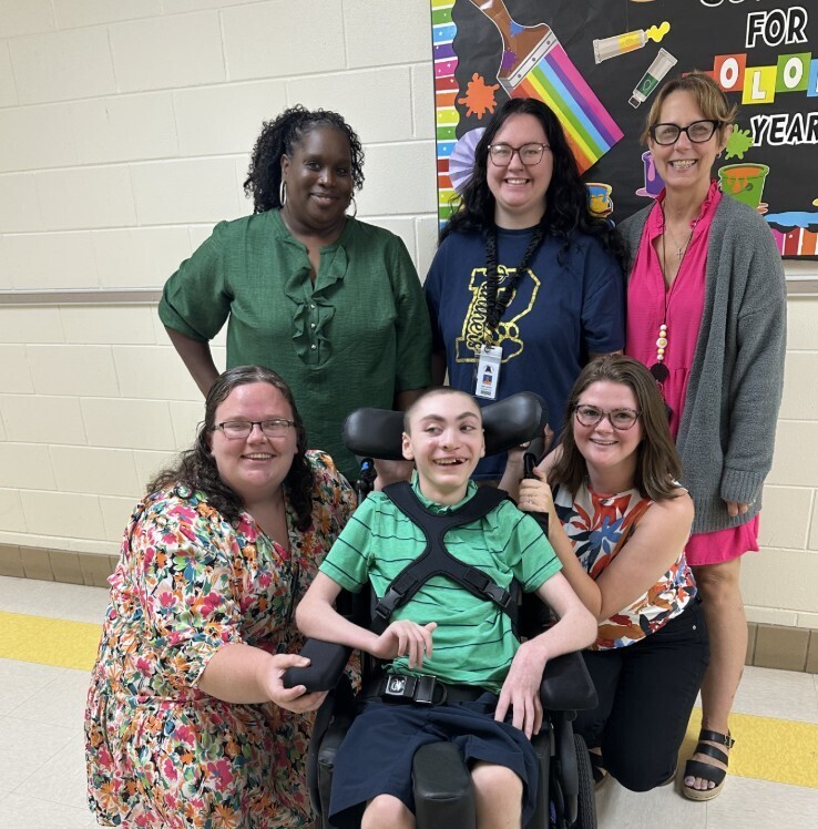 Jag level student with three teachers and two paraprofessionals smiling for meet the teacher