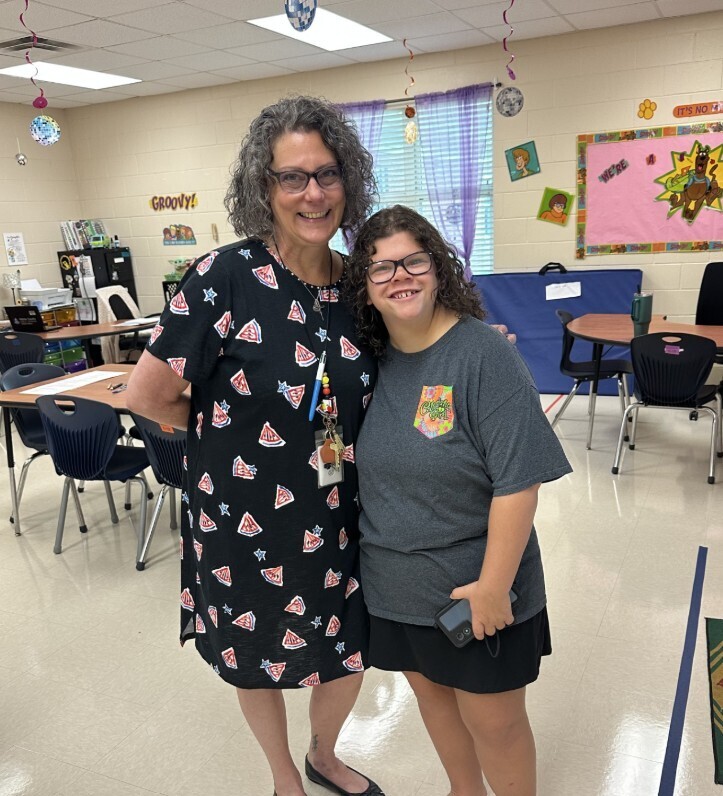 Cougar level student and teacher smiling in the classroom