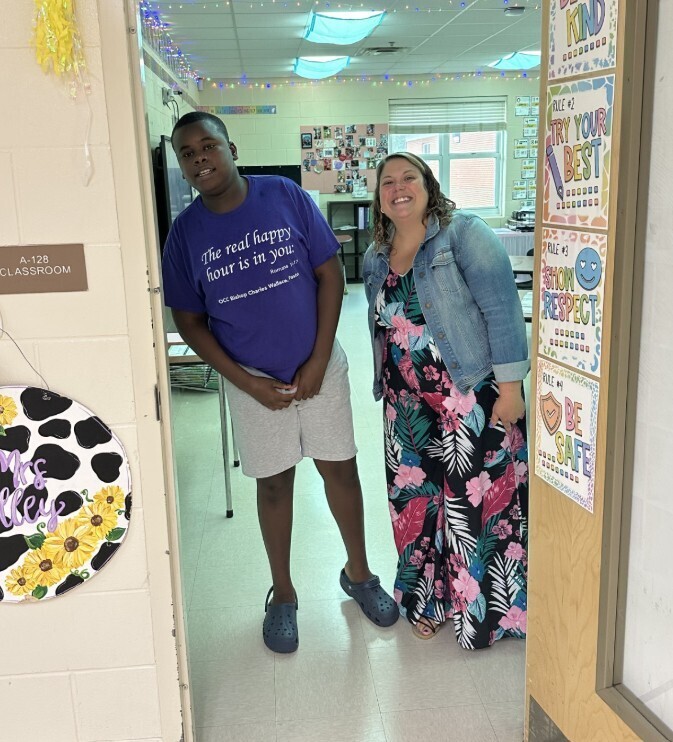 Jag level teacher with student in door way smiling for Meet the teacher