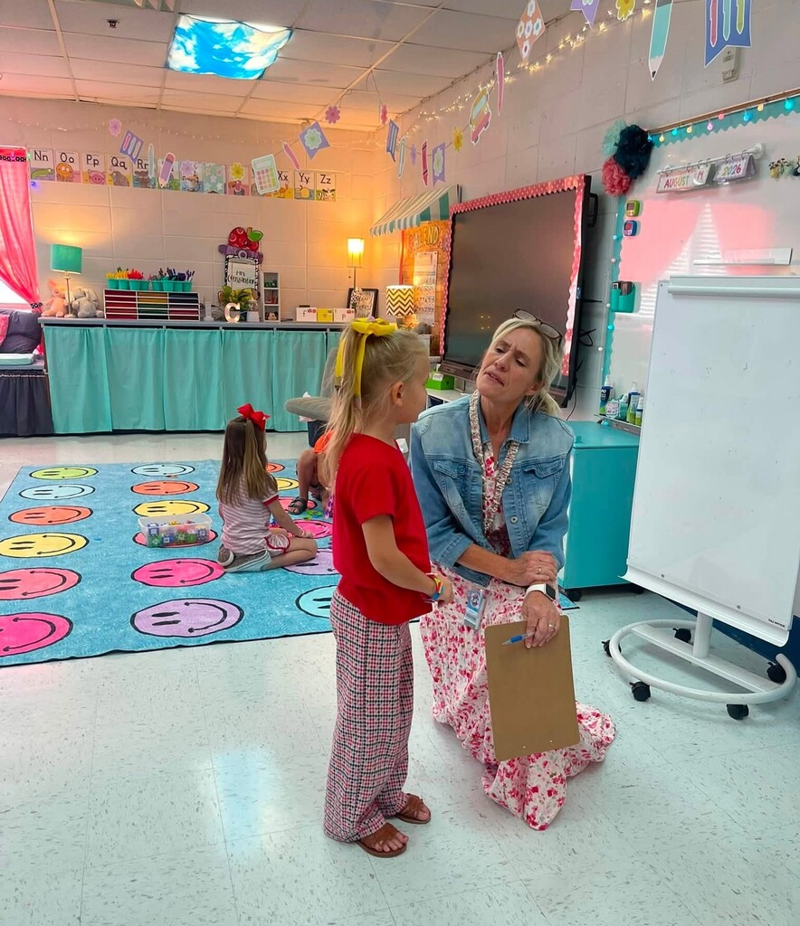 A teacher talks with a student in a classroom