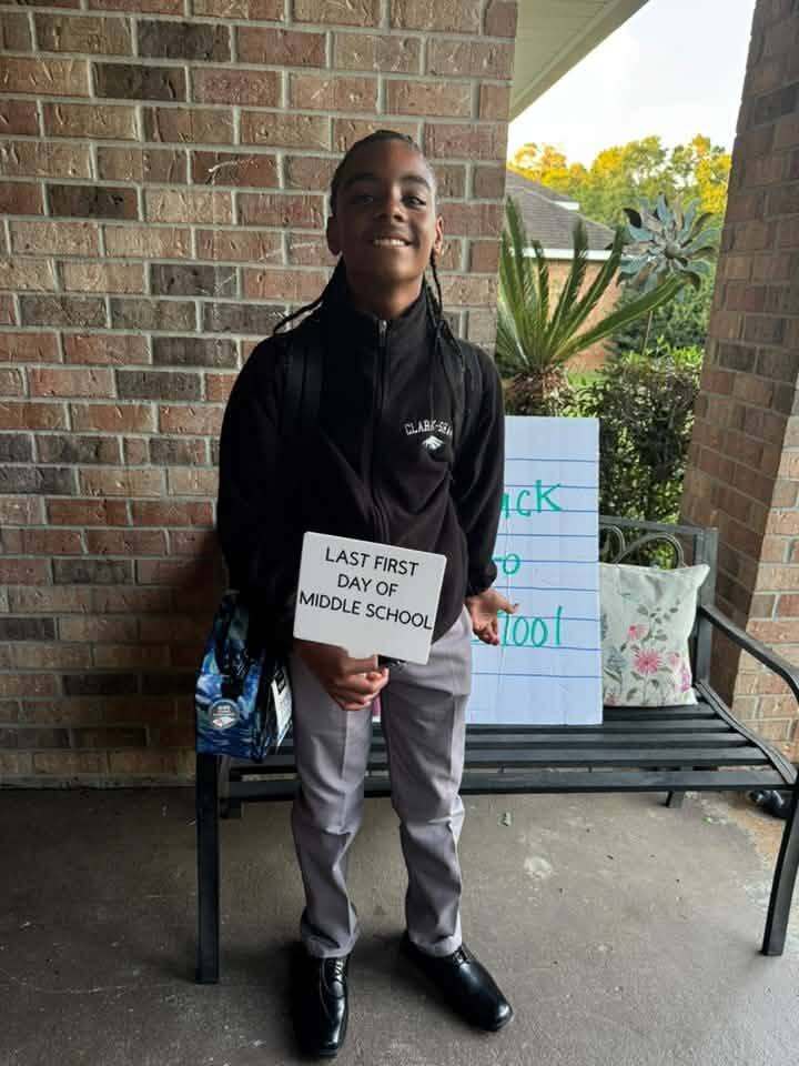 A boy holding a sign that reads "Last First Day of Middle School"
