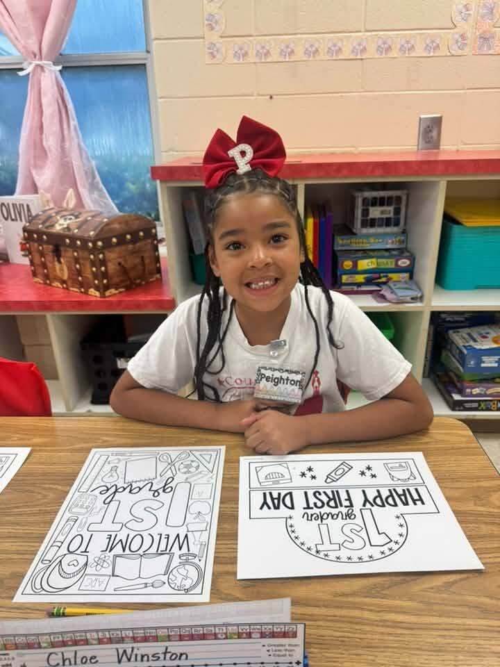 A girl seated at a desk in a classroom