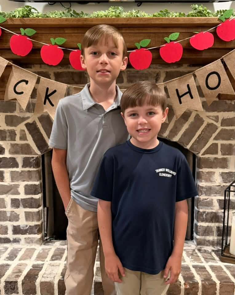 Two boy standing in front of a fireplace