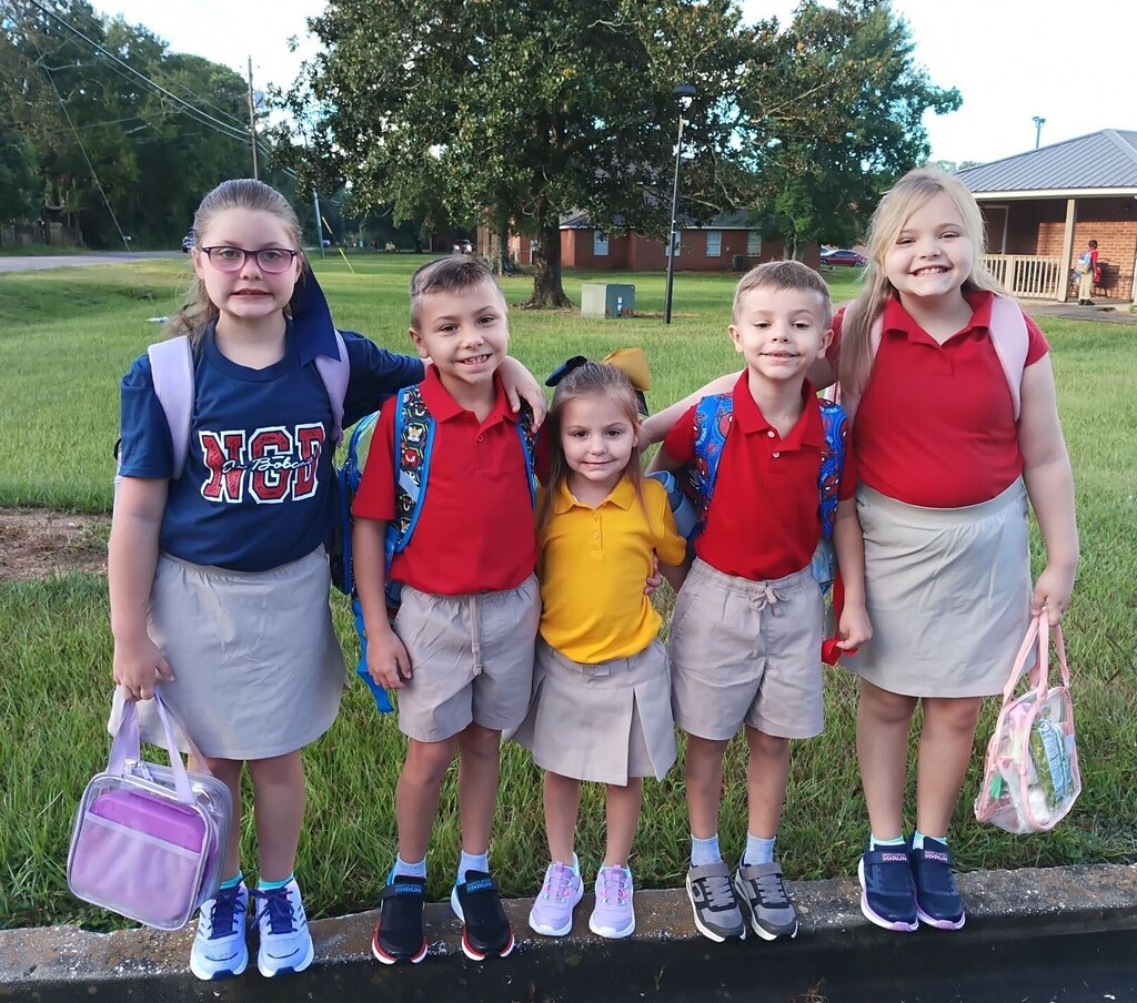 Five students standing on a curb
