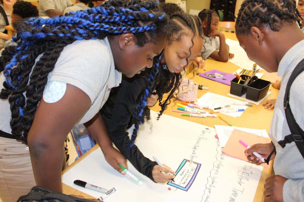 Three students working on a poster