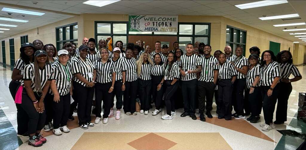 A large group of teachers wearing striped referee's shirts