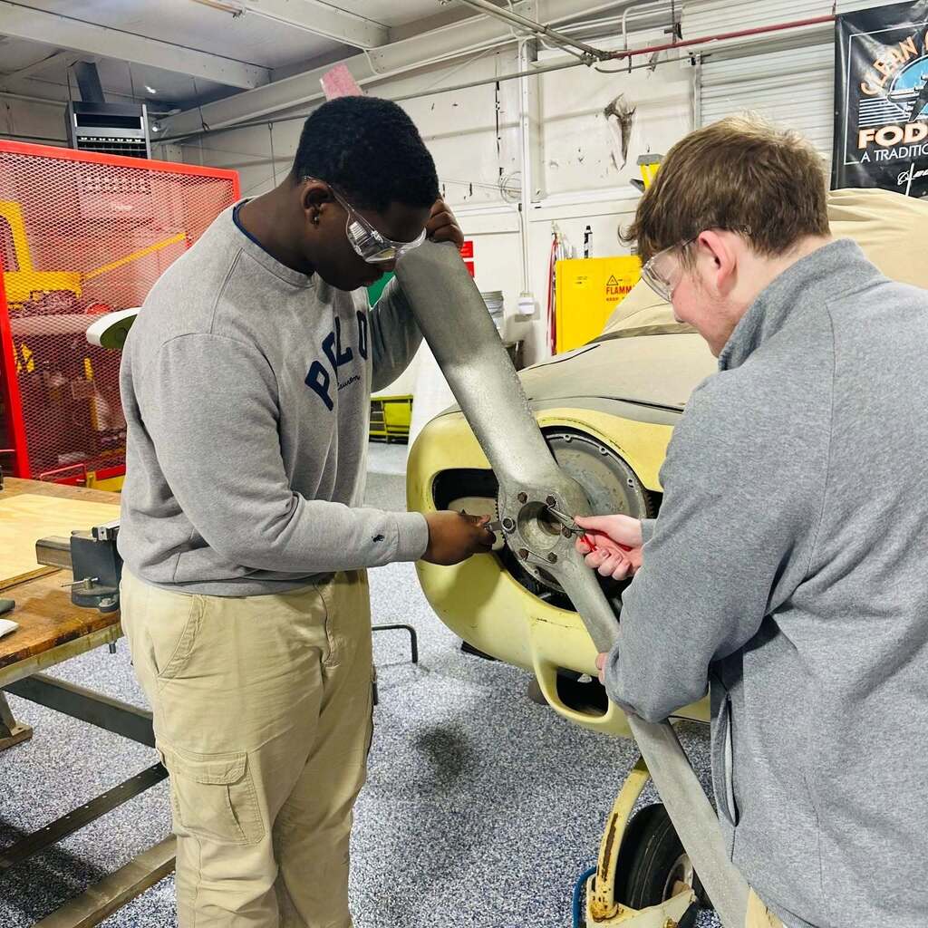 Two students working on an airplane propeller