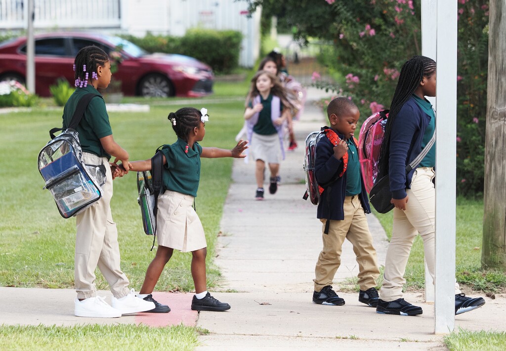 Students wearing backpacks and walking to school