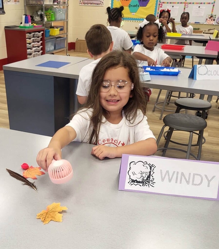 A student blowing on objects with a small fan