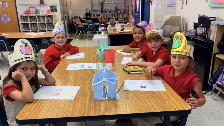 ms. richardson’s kindergarten students sitting at their tables working on the letter A  