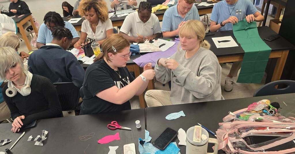 Students working to complete their Lucky Fish in the Textile Club.