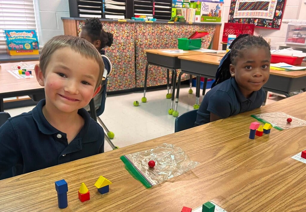 Two students with math manipulatives on the table in front of them