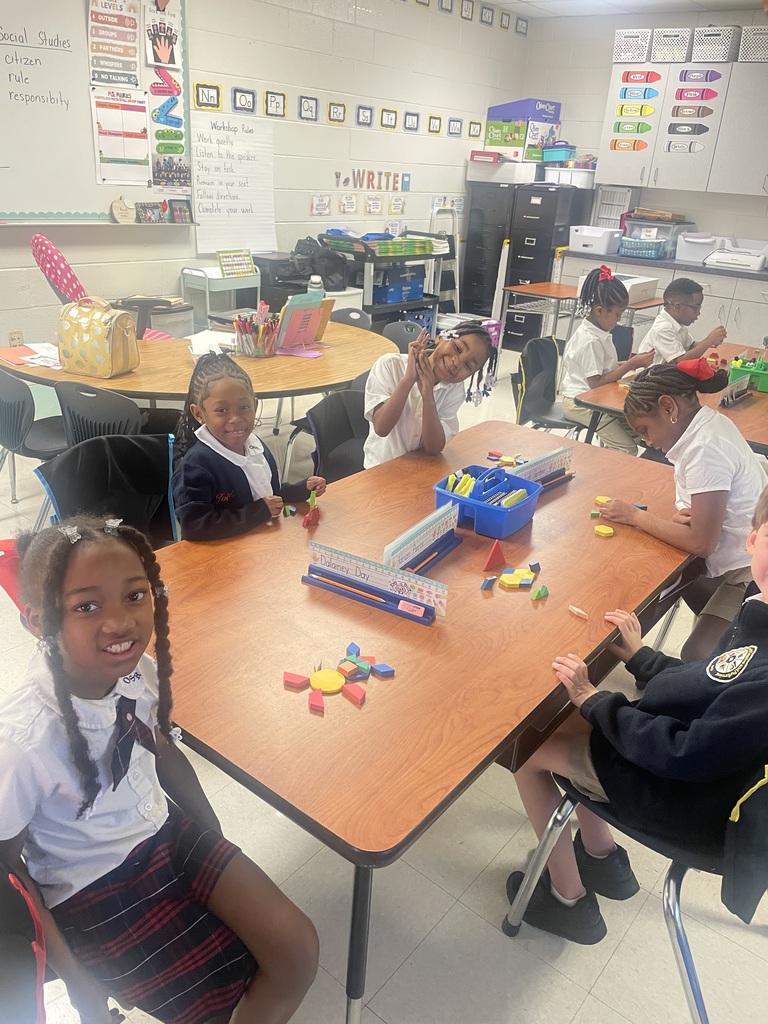Students sorting shapes by their attributes while creating patterns.