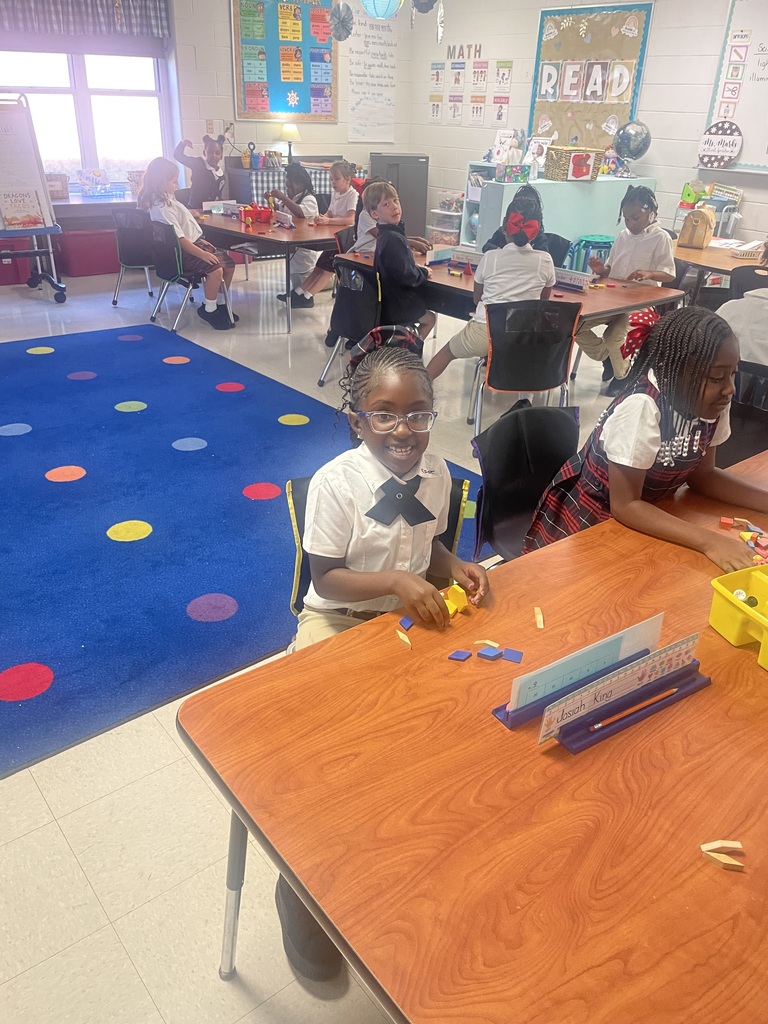 Students sorting shapes by their attributes while creating patterns.