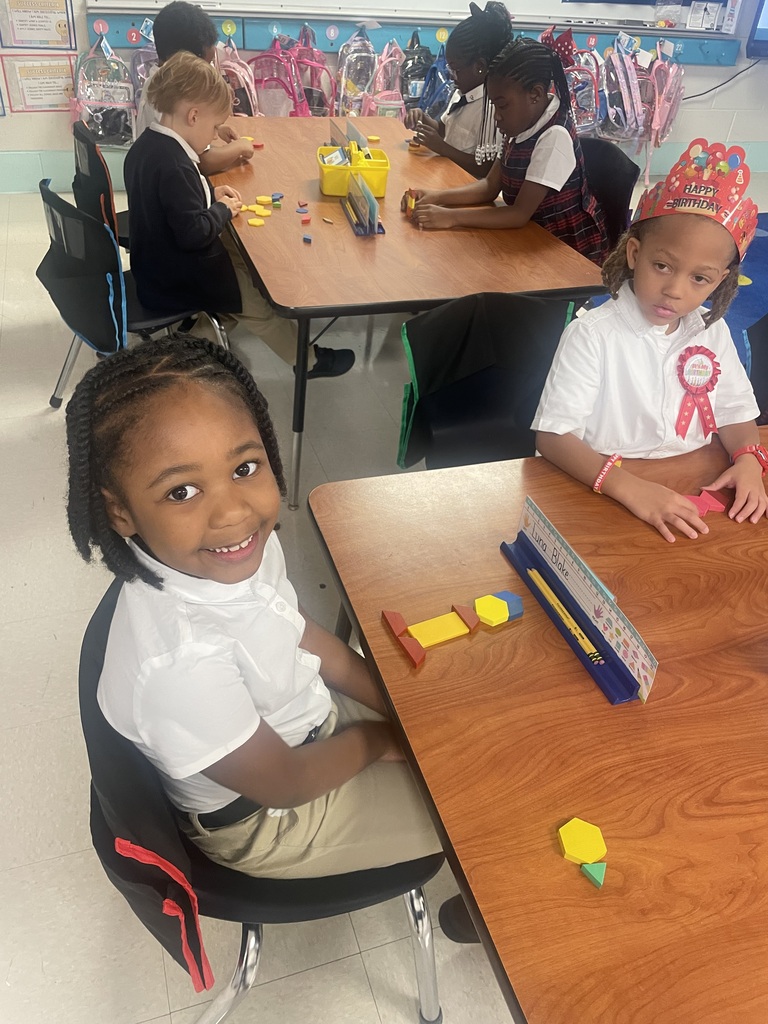 Students sorting shapes by their attributes while creating patterns.