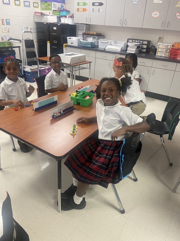 Students sorting shapes by their attributes while creating patterns.