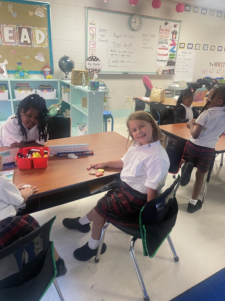 Students sorting shapes by their attributes while creating patterns.