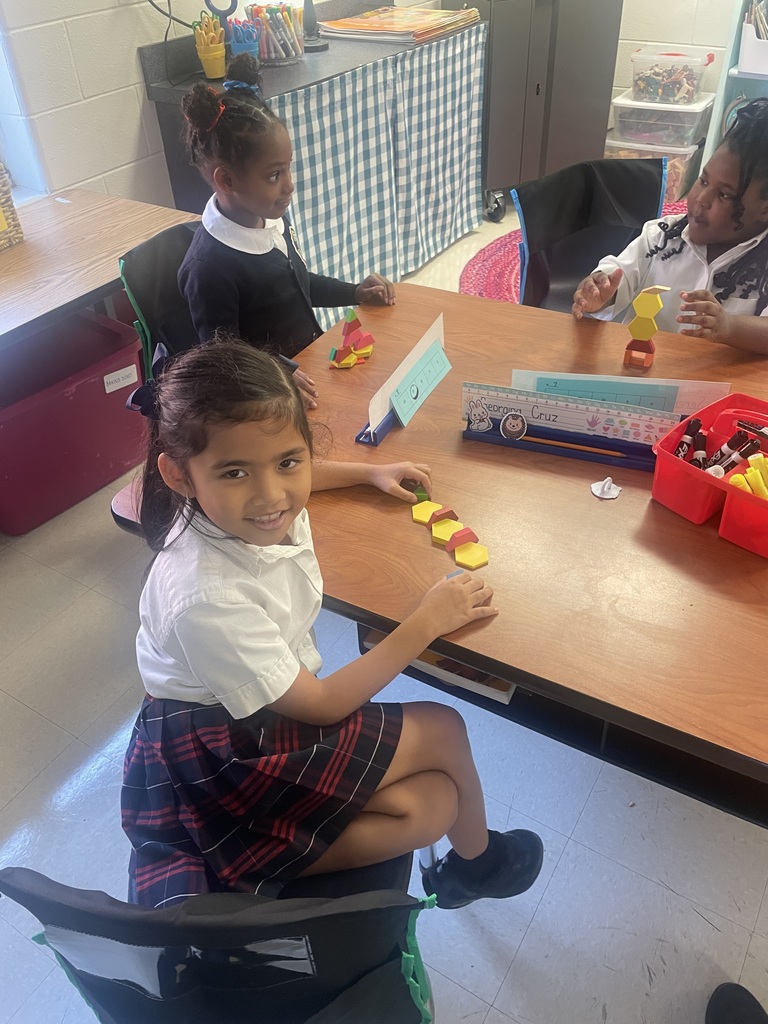 Students sorting shapes by their attributes while creating patterns.