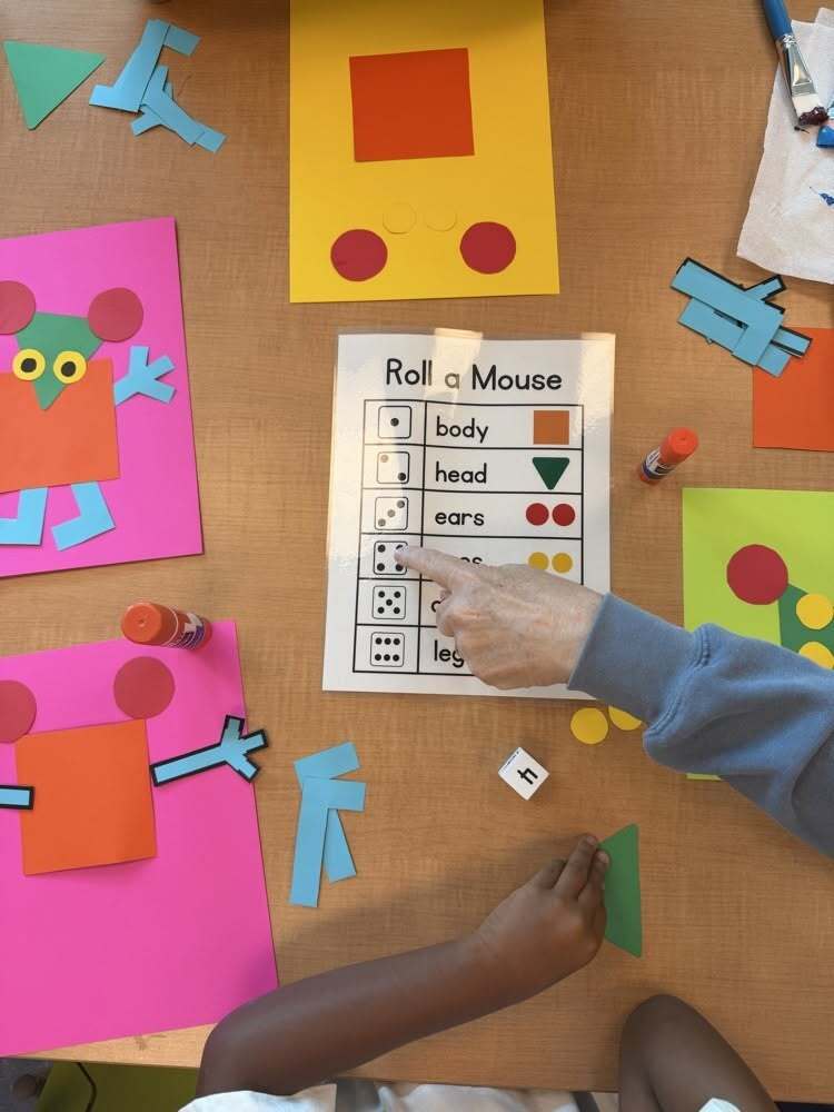 Two hands pointing to a sheet that reads "Roll a Mouse"