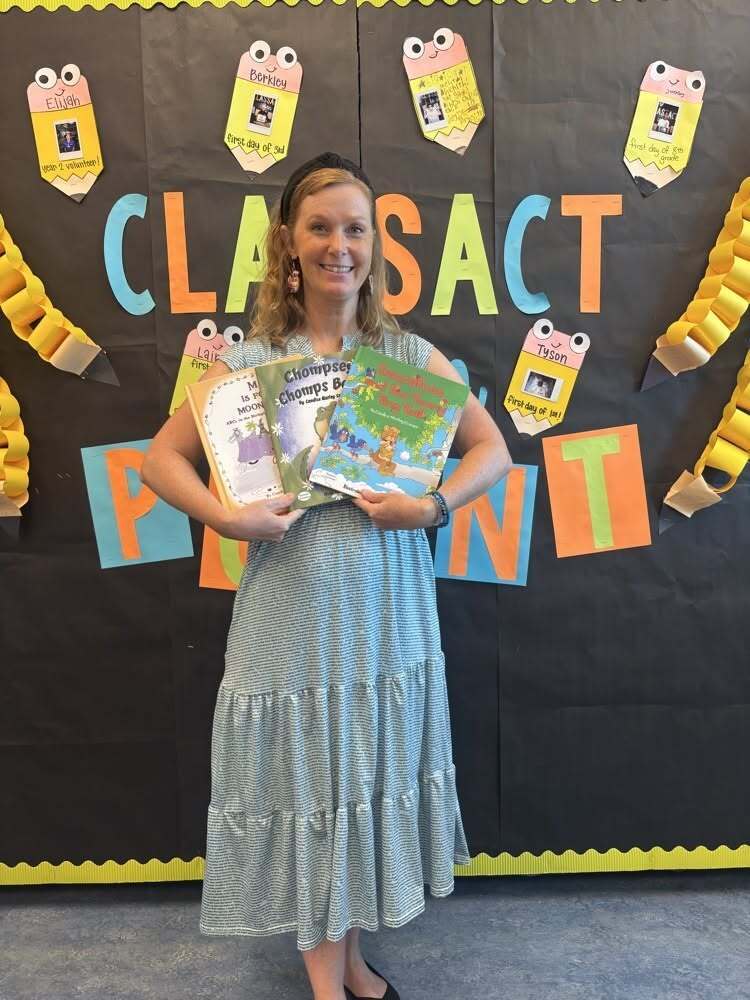 A woman holding three books