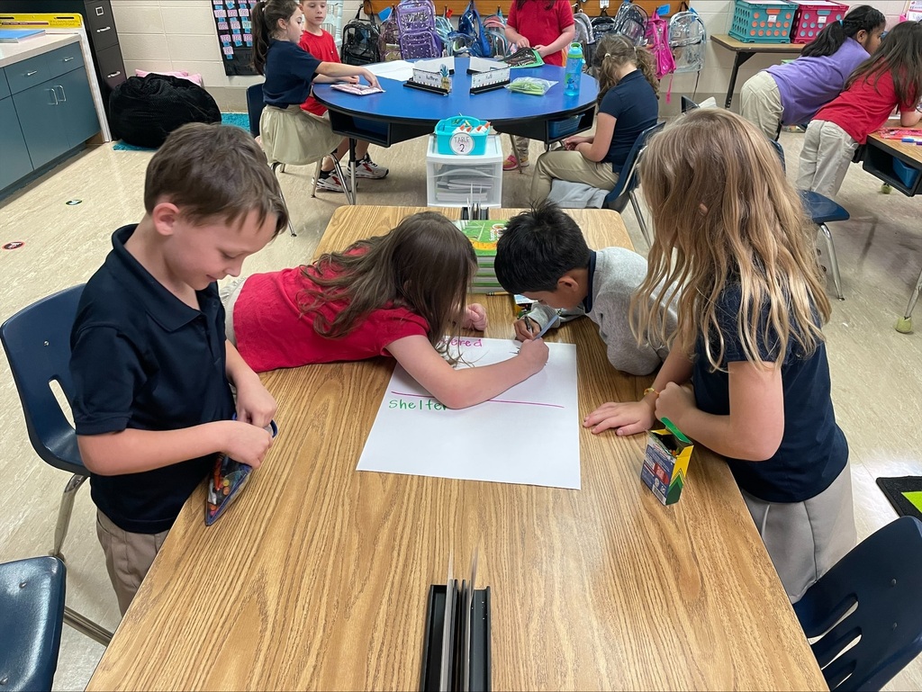 students using crayons and markers to work on a poster together
