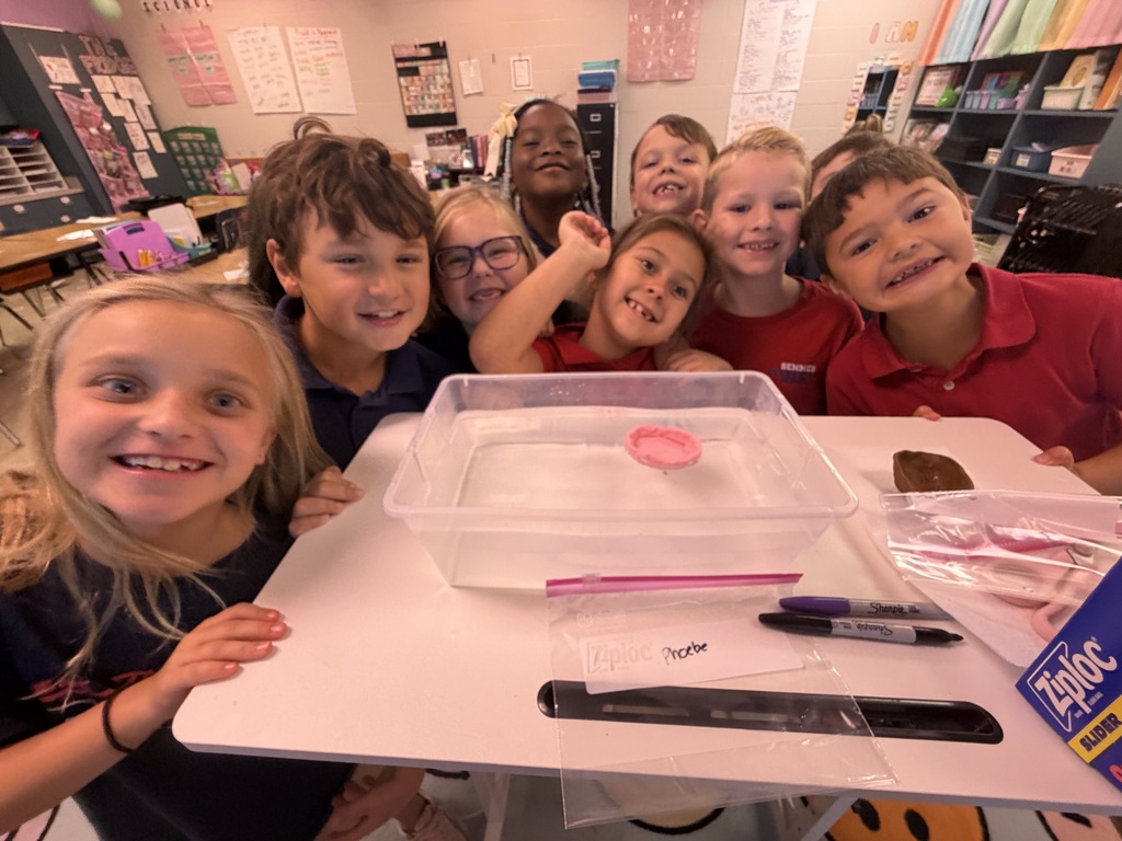 smiling students around an object floating in water