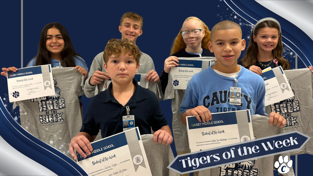 A group of children standing with certificates, one holds a "Tigers of the Week" sign.