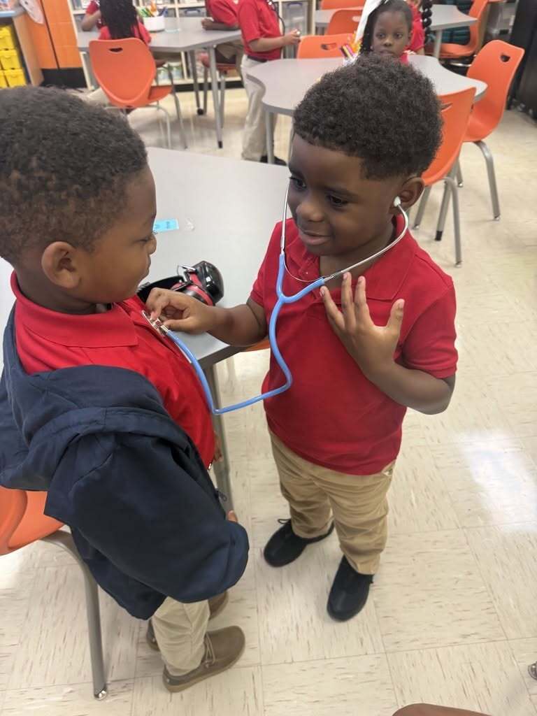 A boy uses a stethoscope to listen to another boy's heartbeat