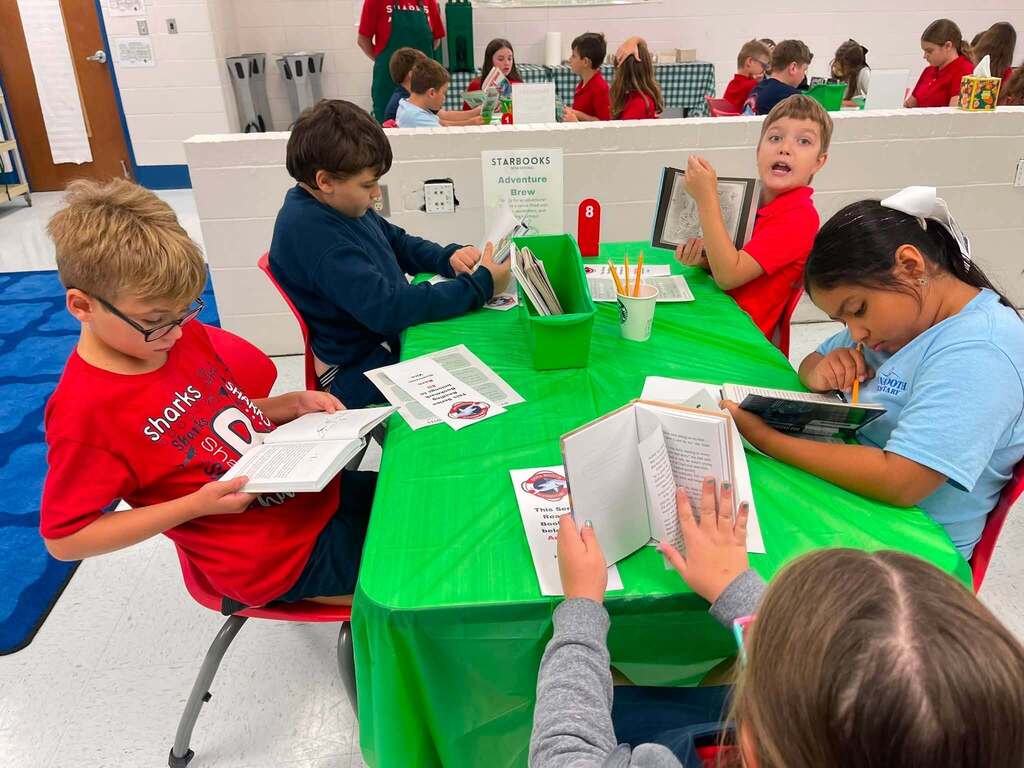 Five students reading at a table