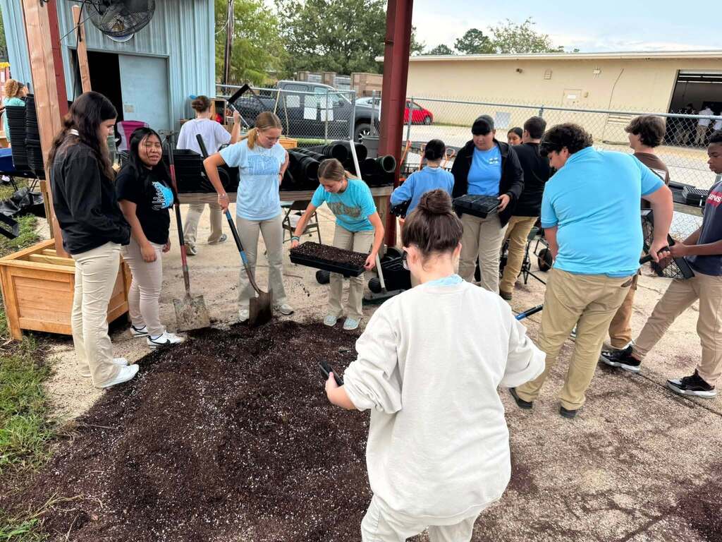 A group of students preparing soil for planting