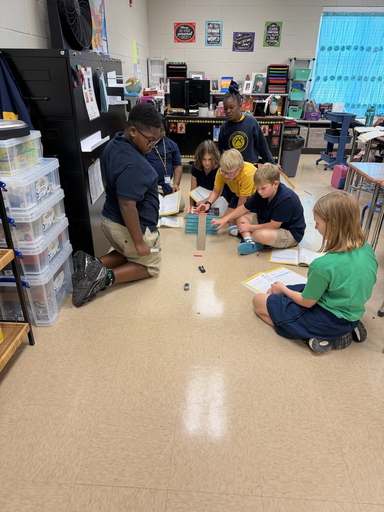 A group of children are on the floor, engaged in an activity with building blocks.