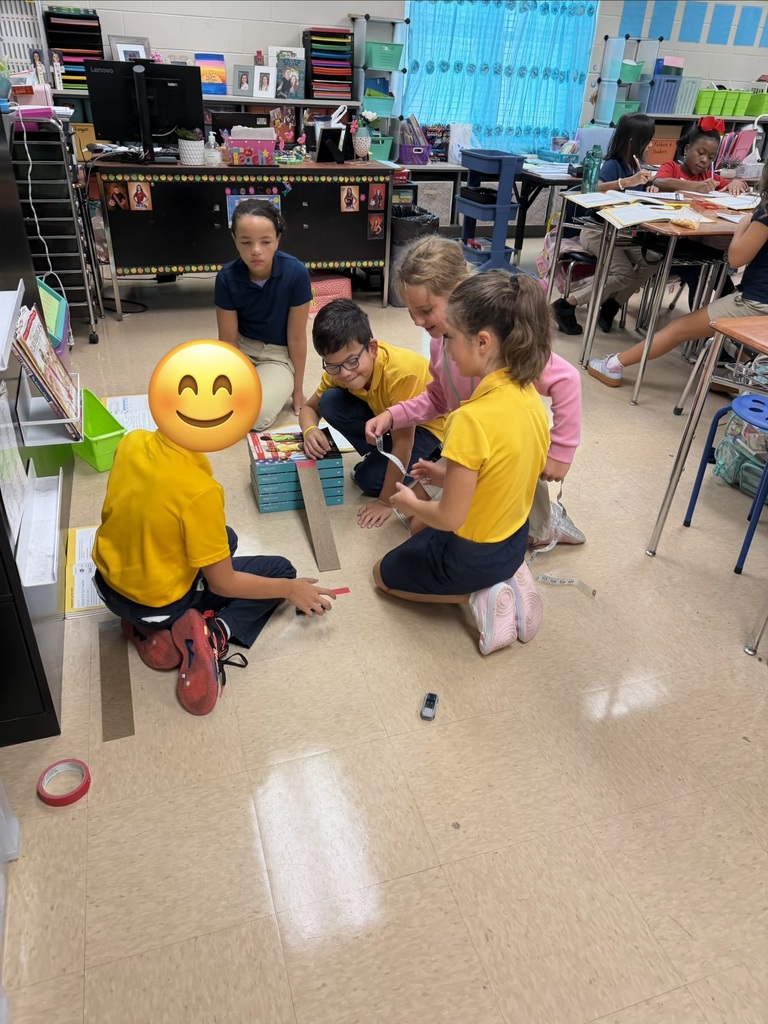 Four children in yellow shirts sitting on the floor. One child is holding a box of crayons. A yellow smiley face is superimposed.