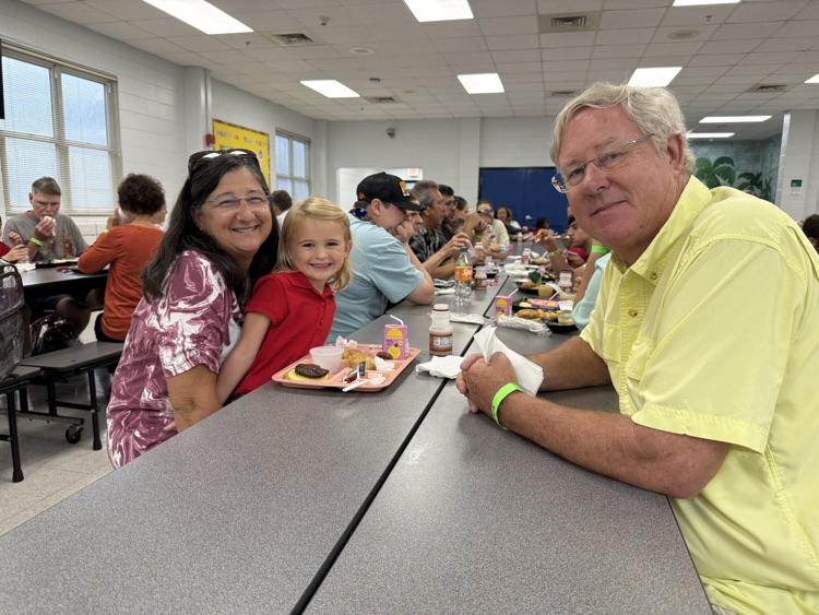 grandparents and students eating breakfast in the cafeteria in the school  