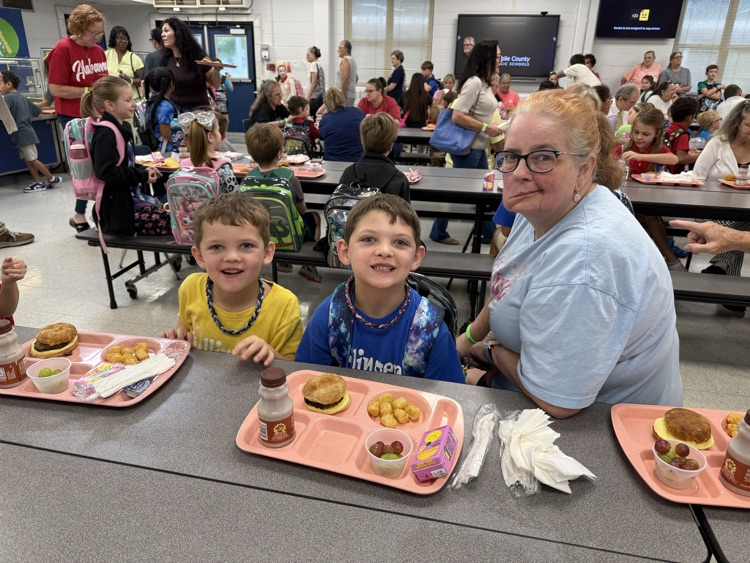 grandparents and students eating breakfast in the cafeteria in the school. 