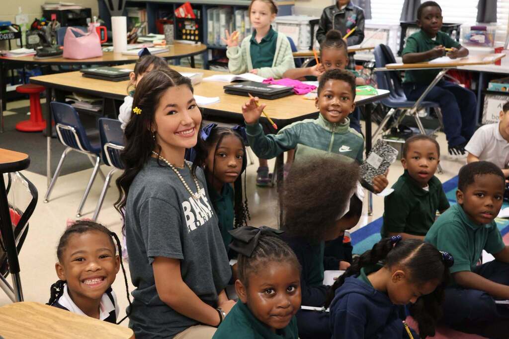 A high school student in a class full of elementary students