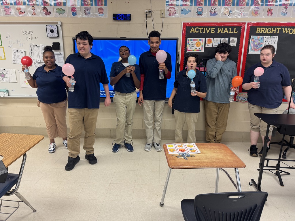 Student picture holding there balloons in front of the class room 