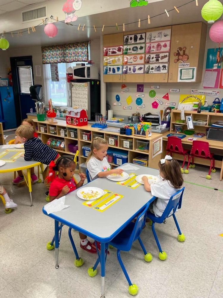 mrs. howell’s prek class describing popcorn using their 5 senses in the classroom. students are sitting at their tables with popcorn on their plates 