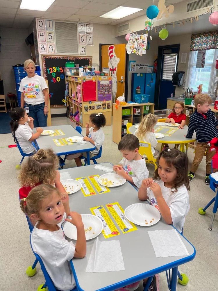 mrs. howell’s prek class describing popcorn using their 5 senses in the classroom. students are sitting at their tables with popcorn on their plates 