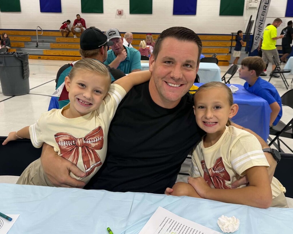 A dad with his two daughters in a cafeteria