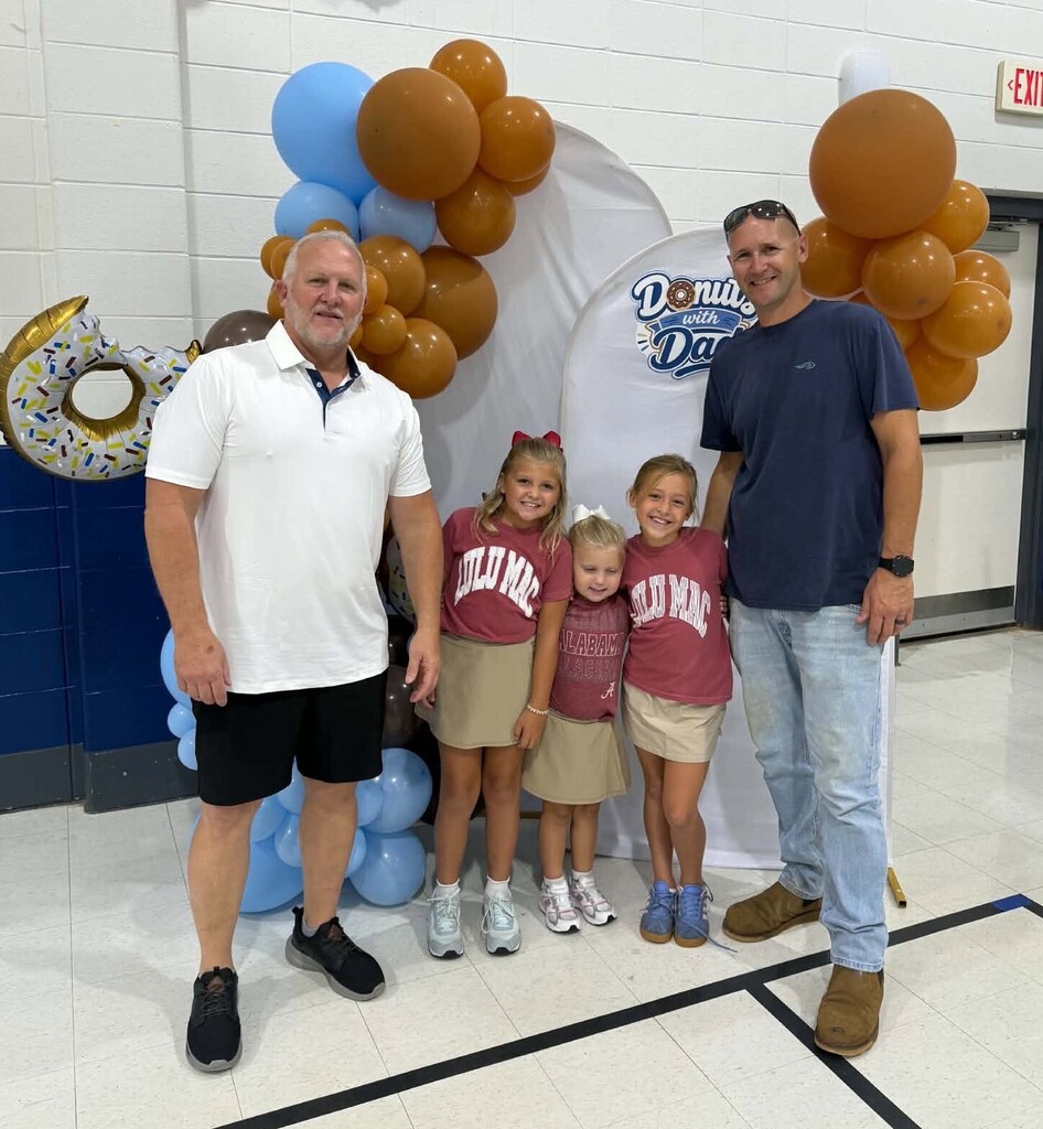 A dad, a grandpa and three girls in a gymnasium