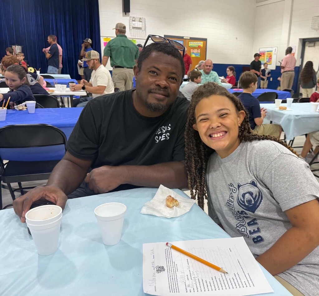 A dad with his daughter in a cafeteria
