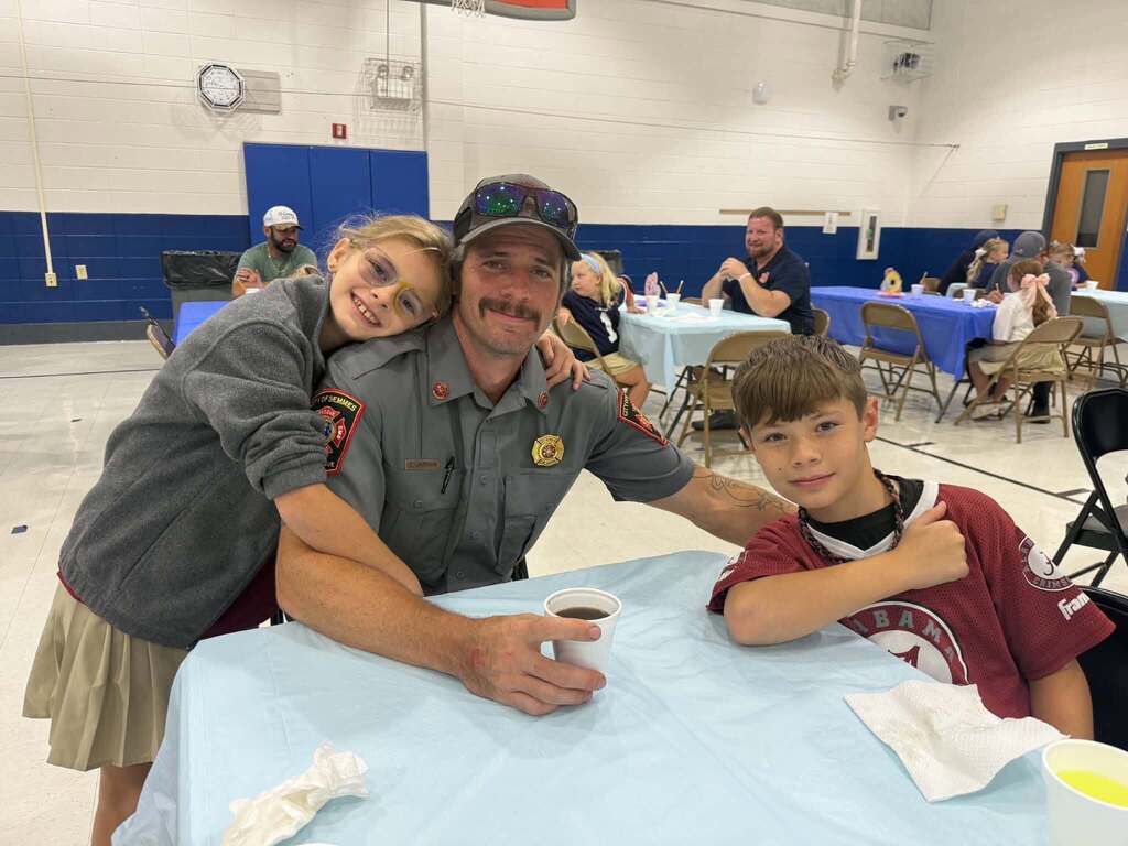 A dad with his daughter and son in a cafeteria