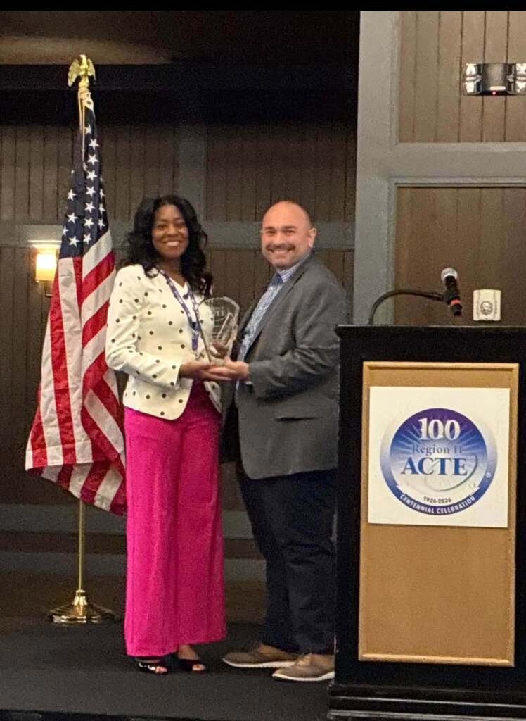 A woman accepting an award from a man