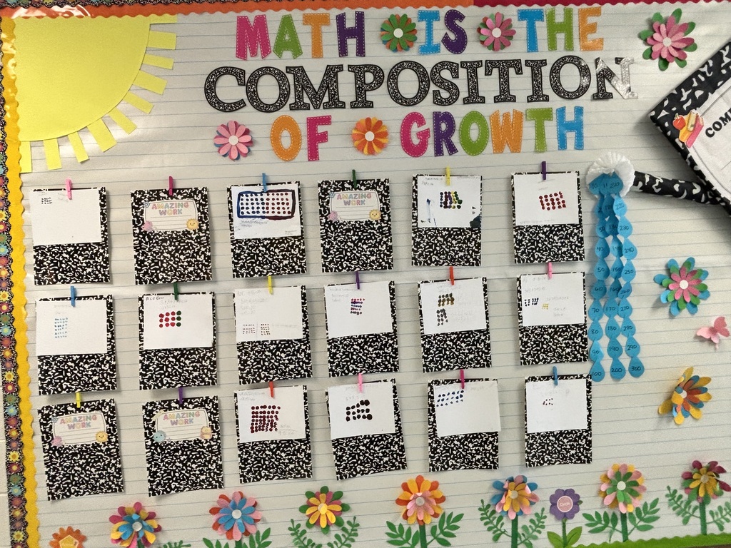 A bulletin board displays the text "MATH IS THE COMPOSITION OF GROWTH" with flowers and sun. Rows of papers are pinned with clips.