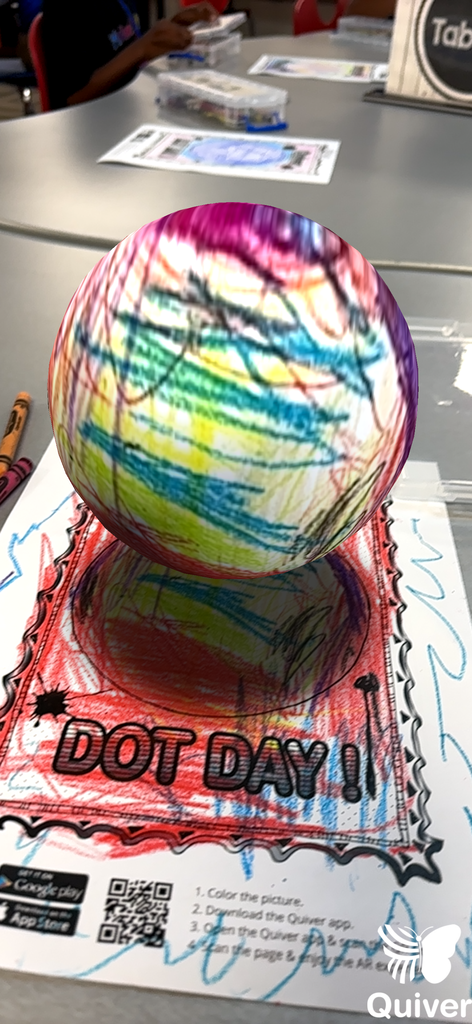 A vibrant, colorful ball rests atop a poster with "Dot Day!" in bold letters. The ball features various colored lines and dots.